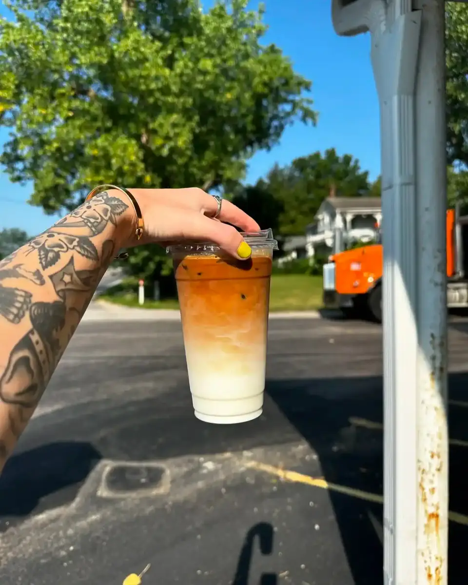 Iced latte held up outside the shop